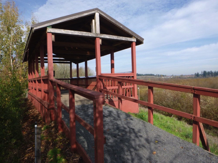 Shelter that overlooks wetlands – wooden railings – ramp with compact gravel transition to wooden surface
